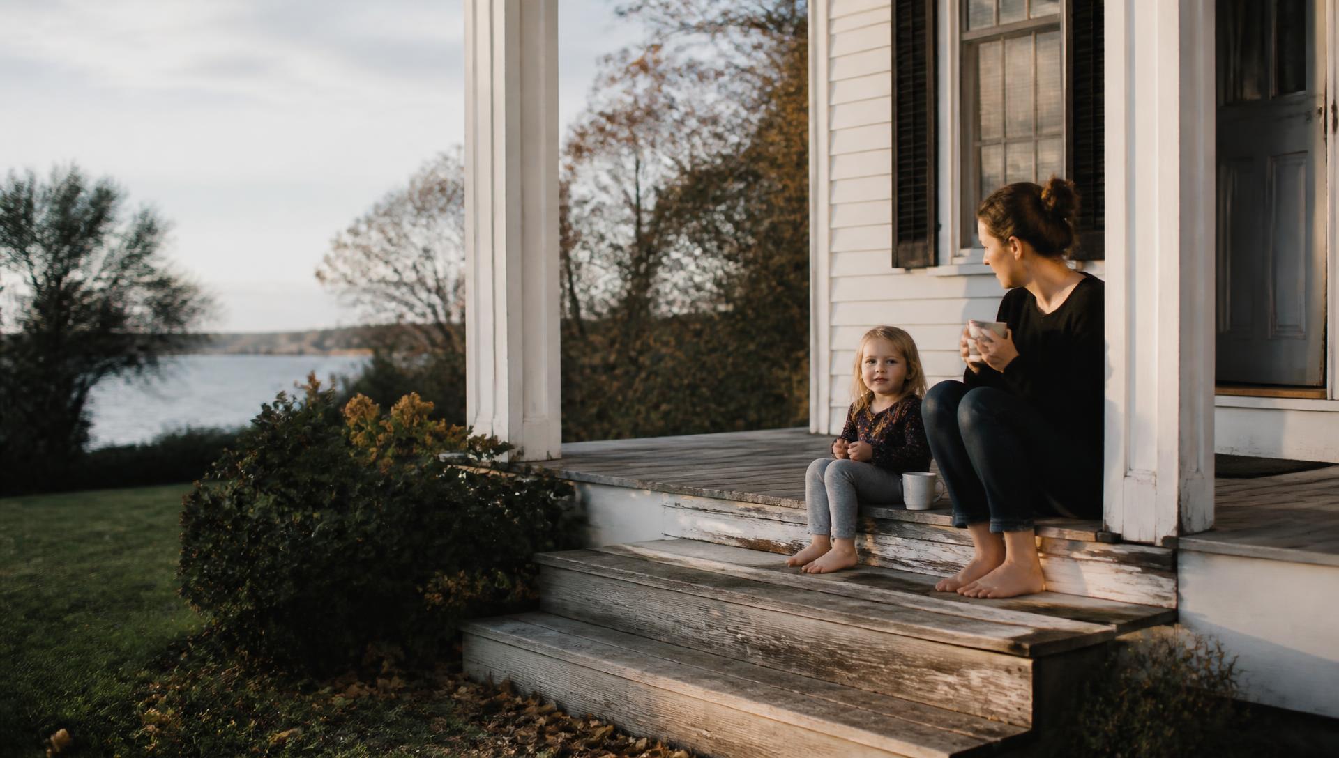 A mother and child together on a New England porch